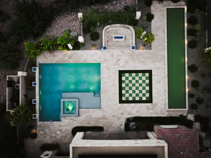 Aerial of a finished backyard with pool, spa and lawn games, filmed by Maken Media