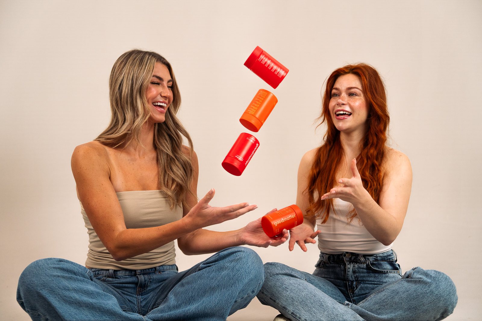 Two women laughing as GoodMatter jars fall around them