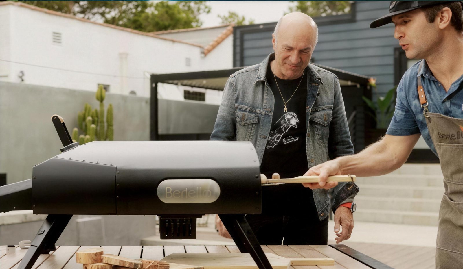 Kevin O'Leary watching a chef pull a pizza from a Bertello oven