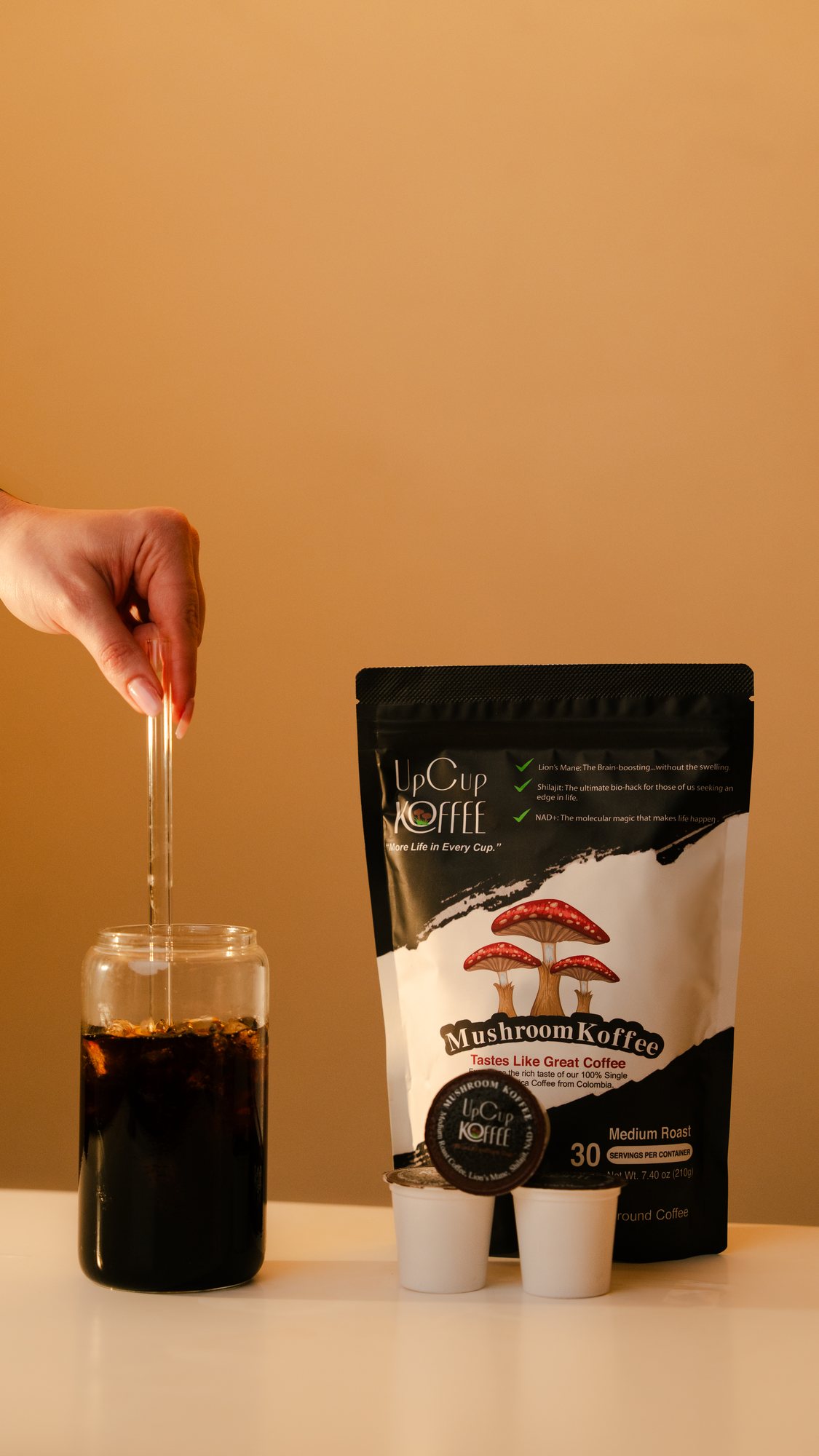 UpCup mushroom coffee bag beside an iced coffee being stirred